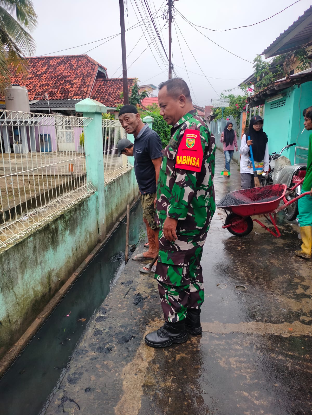 Peltu Adi dan Sertu Sugi Bersama Warga Melaksanakan Bakti TNI Gotong Royong Bersihkan Saluran Air 1