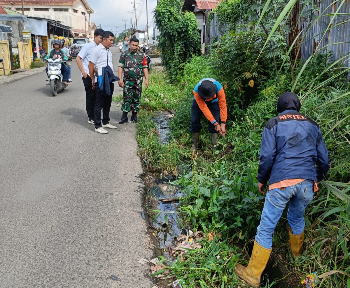 Babinsa 20 Ilir 4 Monitoring Tim PUPR Yang Sedang Membersihkan Parit Yang Kotor dan Sampah 1