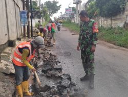 Babinsa Kel Sukajaya Mendampingi Tim PUPR Dalam Perbaikan Jalan