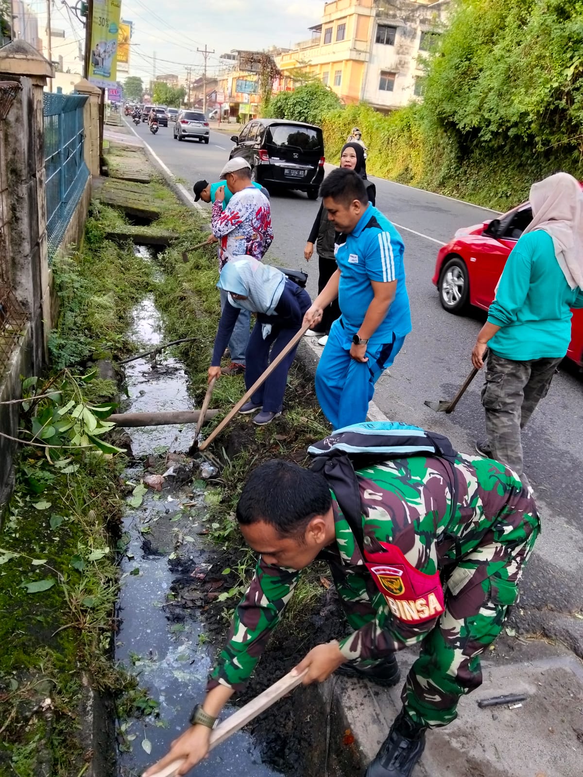 Babinsa Koramil 418-05/Lemabang Bersama Warga Gelar Bhakti TNI Bersihkan Selokan dan Jalan di Kelurahan Duku 2